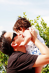 Image showing father in early thirties gives his son a kiss on the cheek in the park 