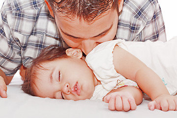 Image showing Father kissing his baby sleeping