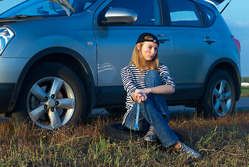 Image showing Young Blond Woman With Her Broken Car