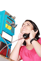 Image showing Beautiful woman happy talking on the public phone