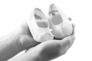 Image showing Hands holding newborn baby shoes