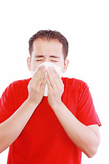 Image showing Young man with a cold blowing nose on tissue 