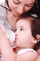 Image showing Mother and baby drinking milk from bottle in a white background