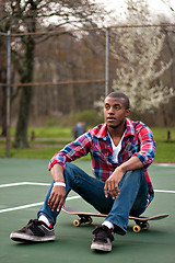 Image showing Skateboarding Guy Taking a Rest