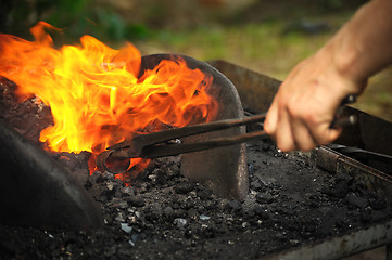 Image showing Blacksmith heating up iron - detail