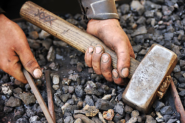 Image showing Detail of dirty hands holding hammer and rod - blacksmith