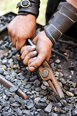 Image showing Detail of dirty hands holding pliers - blacksmith