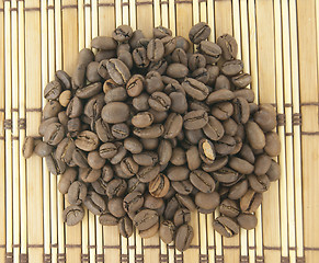 Image showing A heap of coffee beans on wooden background