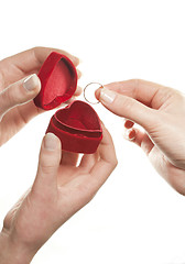 Image showing Hands with a heart shaped box and a ring on white background