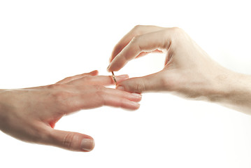 Image showing Man's hand passing through the ring onto woman's finger