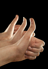 Image showing Three hands gesturing fingers up on black background