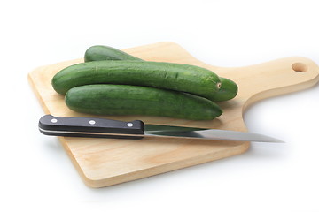 Image showing Cutting cucumbers on the wooden board
