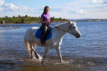 Image showing The girl led the horse to swim