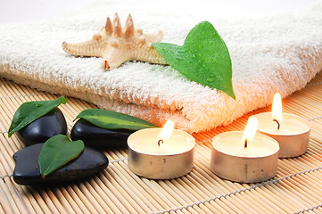 Image showing foldet white bath towel and zen stones