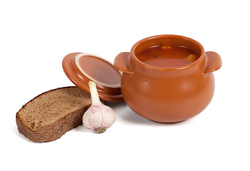 Image showing Borsch in clay pot with bread and garlic