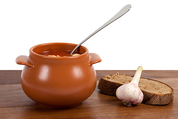 Image showing Borsch in clay pot on wooden table