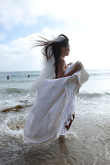 Image showing Woman Running in the Ocean in her White Wedding Dress