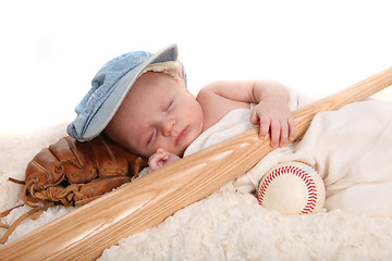 Image showing Infant Boy Holding Baseball Bat and Sleeping on a Glove