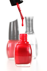 Image showing Nail Polish Dripping Into a Bottle of Red Enamel
