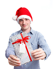 Image showing Man with santa hat holding christmas present