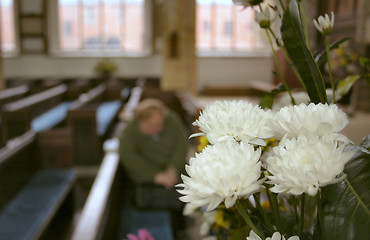 Image showing flowers in church and a person in prayer