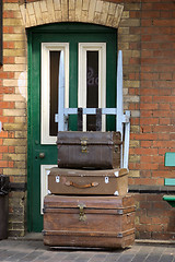 Image showing old trunks in front of a  green door