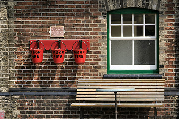 Image showing fire buckets and seat in front of a window at a railway museum