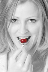 Image showing Pretty woman eating a cherry