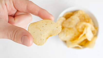 Image showing Hand with potato chip