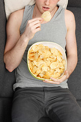 Image showing Man eating chips