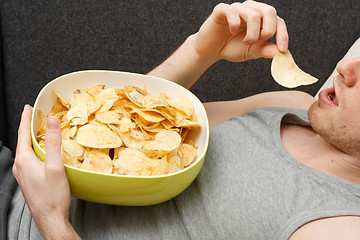 Image showing Man eating chips