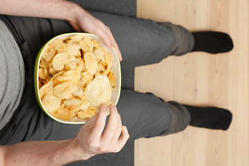 Image showing Man eating chips