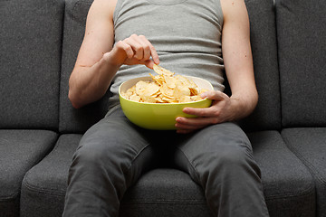 Image showing Man eating chips