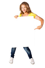 Image showing Happy young woman holding a blank billboard