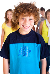 Image showing Smiling kid in focus with family posing in the background