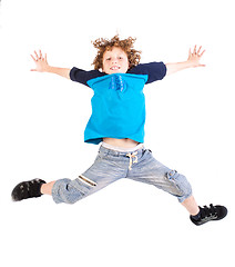 Image showing Attractive young kid jumping high, indoors