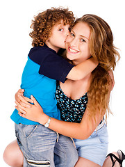 Image showing Young kid kissing his mom and looking at camera