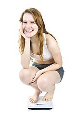 Image showing Smiling young girl on bathroom scale