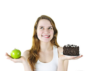 Image showing Young girl holding apple and cake