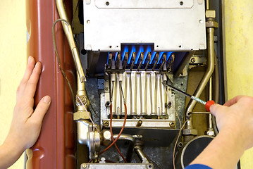 Image showing hands of a plumber repairing a gas heating 