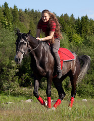 Image showing A girl riding a horse at a gallop