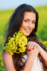 Image showing girl with flowers at summer field