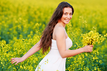 Image showing girl with flowers at summer field