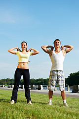 Image showing Young man and woman doing stretching exercises