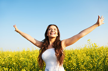 Image showing girl with hands up at summer field