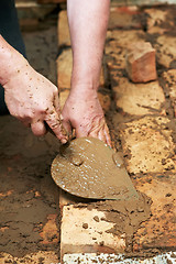 Image showing Mason hands at bricklaying works