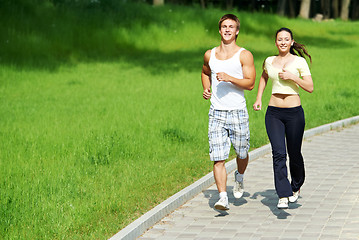 Image showing Young man and woman jogging outdoors