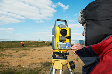 Image showing surveyor works with theodolite tacheometer