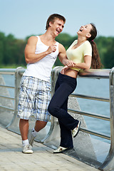 Image showing Young man and woman relaxing after jogging