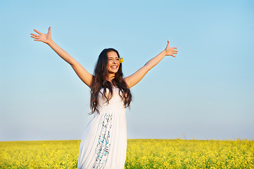 Image showing girl with hands up at summer field